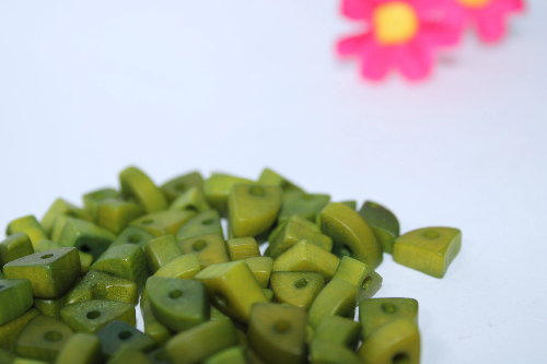 Mini tagua nuts in the shape of triangles. Green color. 100 pieces. Approx. 1cm x 0.7mm. Perforated in the center. Jewelry making TBTGreen02